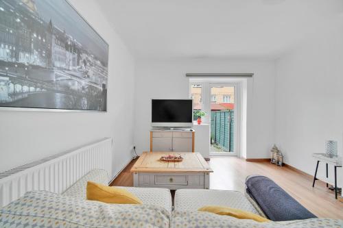 a living room with a couch and a tv at The Cosy Flat in Bethnal Green in London