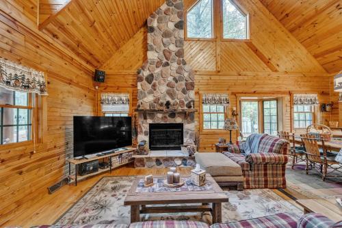 a living room with a stone fireplace and a tv at Woodlands Cabin Retreat in Oxford cabin in Oxford
