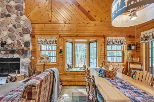 a log cabin dining room with a stone fireplace at Woodlands Cabin Retreat in Oxford cabin in Oxford
