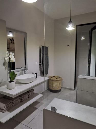 a white bathroom with a sink and a mirror at 69 Lagoon Suite in Marina Beach