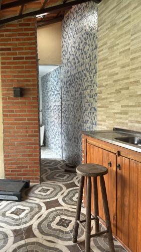 a kitchen with a counter and a stool in a room at Refúgio em São Pedro da Serra in Nova Friburgo