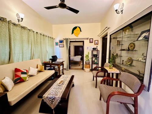a living room with a couch and chairs and tables at The Mango Tree by ANAND VILLA in Jodhpur