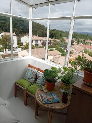 - un balcon avec un canapé et une table ornée de plantes dans l'établissement T3 campagne d'Aix-en-Provence, à Meyrargues