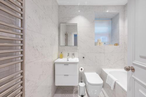 a white bathroom with a toilet and a sink at Casa Italia near Sloane Square, Harrods and Kings Road - Washing Machine & Wifi in London