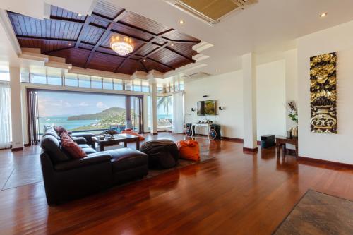 a living room with a couch and a table at Grand View Panwa Luxury Villa in Ban Ao Makham