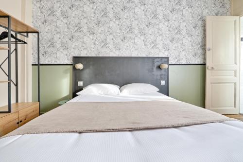 a bedroom with a large bed with a black headboard at Le Florus in Montrouge