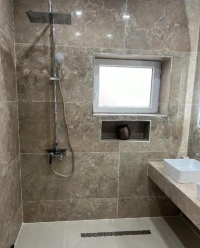 een badkamer met een douche, een wastafel en een raam bij Cassa Massa in Kyustendil
