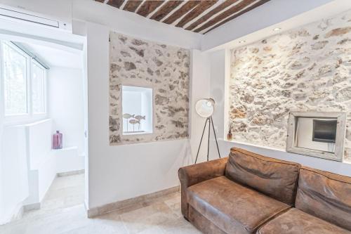 un salon avec un canapé et un mur en pierre dans l'établissement Superbe 2 Pièces - Viel Antibes, à Antibes