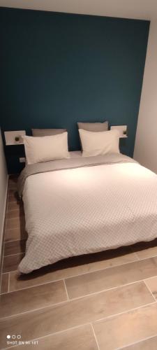 a bedroom with a large bed with white pillows at Les Suites du Relais in Saint-Martin-dʼAblois