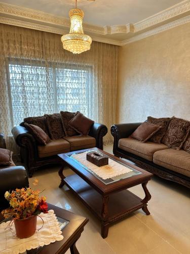 a living room with couches and a coffee table at shafa badran شفا بدران ام الحجير in Amman