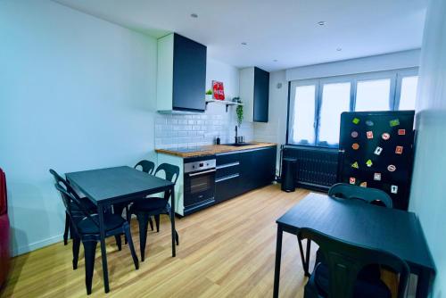 une cuisine avec une table et des chaises dans une pièce dans l'établissement ValenStay - Duplex Stade du Hainaut avec terrasse, à Valenciennes