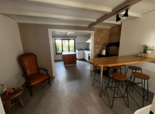 a kitchen and living room with a wooden table and chairs at Gîte Familie in Meyenheim