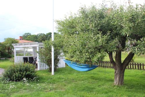 a blue hammock hanging from a tree in a yard at Villa Blueberry in Överum