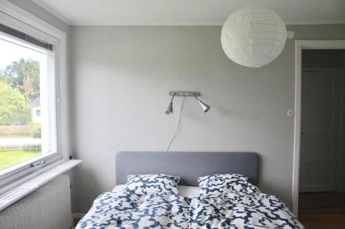 a bedroom with a bed and a lamp and a window at Villa Blueberry in Överum