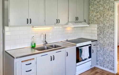 a kitchen with white cabinets and a sink at Villa Blueberry in Överum