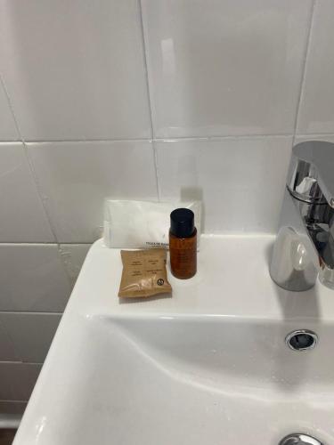 a bathroom sink with a bottle of iodine on it at Playa Arena Grande in A Guarda
