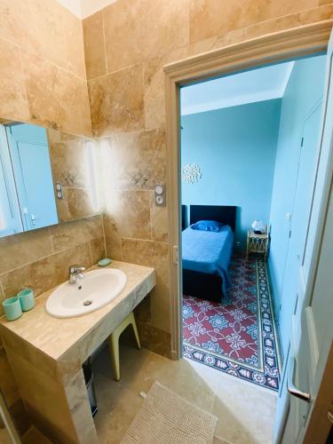 d'une salle de bains avec lavabo et d'une chambre. dans l'établissement Soleil d'Or - Appartement curistes balcon - terrasse, à Lamalou-les-Bains