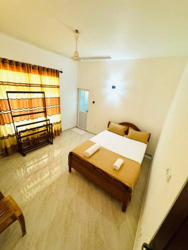 a small bedroom with a bed and a window at Ahasna Airport Villa in Negombo