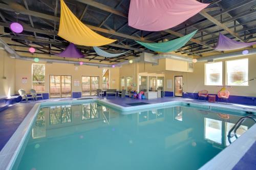 a pool with umbrellas hanging from the ceiling at Lincoln Resort Condo with Ocean Views and Pool Access in Lincoln City