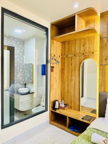 a bedroom with a bathroom with a sink and a mirror at Agape House Và Apartment in Da Lat