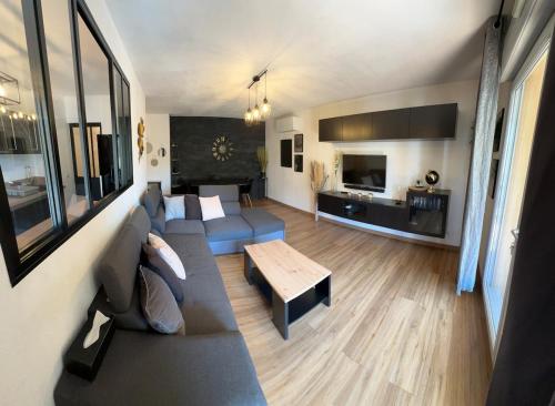 un salon avec un canapé et une table dans l'établissement Appartement calme et spacieux à Aix en Provence, à Aix-en-Provence