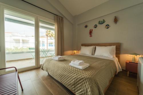 a bedroom with a bed with two towels on it at Aegean Twin Houses in Iraklitsa