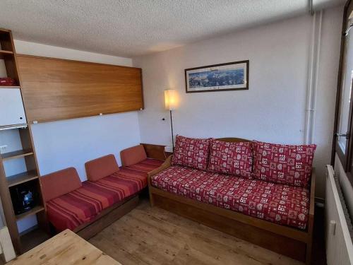 - un salon avec un canapé rouge dans l'établissement Studio fonctionnel aux pistes · Casier à skis · Mont Blanc - FR-1-181-2655, à La Plagne Tarentaise