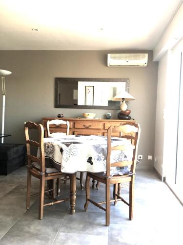 une salle à manger avec une table, des chaises et un miroir dans l'établissement Les Anthemis- Bord de mer, à Saint-Raphaël