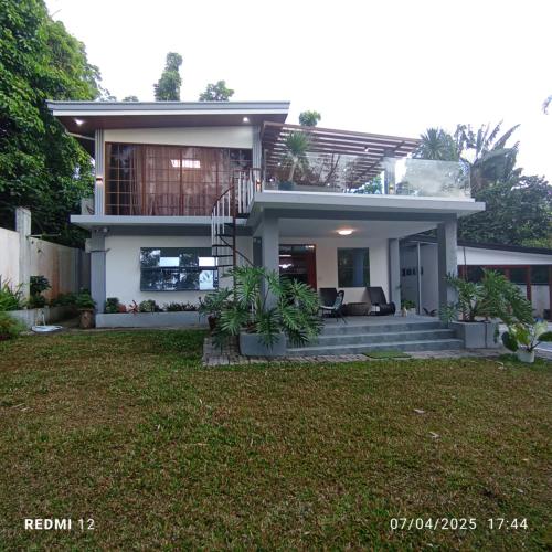 a house with a lawn in front of it at Jachim and Boaz FarmVille Staycation in Tagaytay