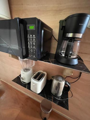 a microwave and a coffee maker on a shelf at El Domo del ALF La Paz entre el bosque y el mar II in Sauce de Portezuelo