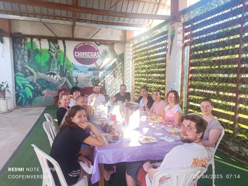 a group of people sitting around a table in a restaurant at Chimicuas House in Puerto Maldonado