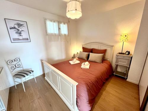 une chambre avec un grand lit et une chaise dans l'établissement Les Oyats, vue sur mer, parking, GR34, à Clohars-Carnoët