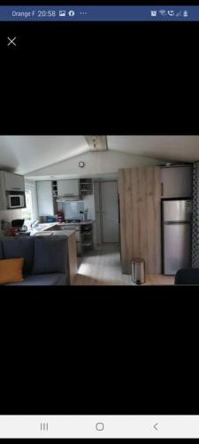 un salon avec un canapé et une cuisine dans l'établissement Camping de la carabasse, à Vias