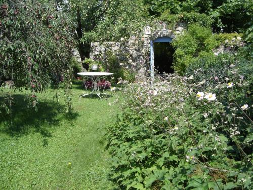 - un jardin avec une table et un bouquet de fleurs dans l'établissement La maison de Mimi, à Ribiers