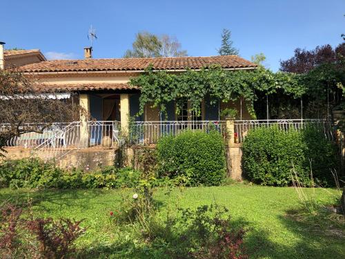 une maison avec une clôture dans une cour dans l'établissement La maison de Mimi, à Ribiers