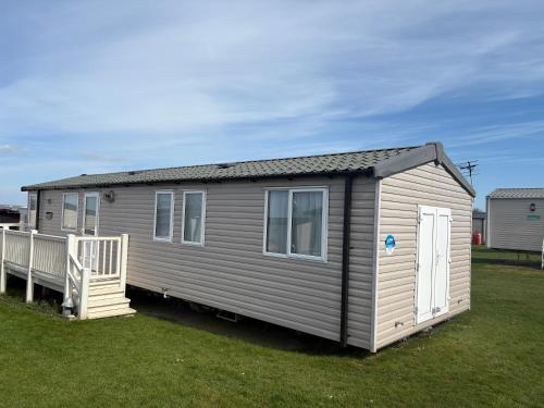 a tiny house sitting on a lawn in a yard at Haven allhallows in Allhallows