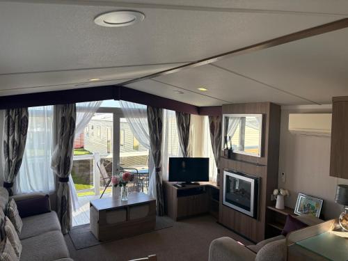 a living room with a couch and a tv at Haven allhallows in Allhallows