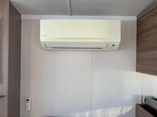 a white air conditioner hanging from a wall at Haven allhallows in Allhallows