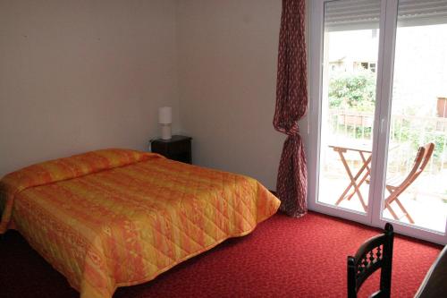 une chambre avec un lit et une porte coulissante en verre dans l'établissement La résidence des bains forts, à Rennes-les-Bains