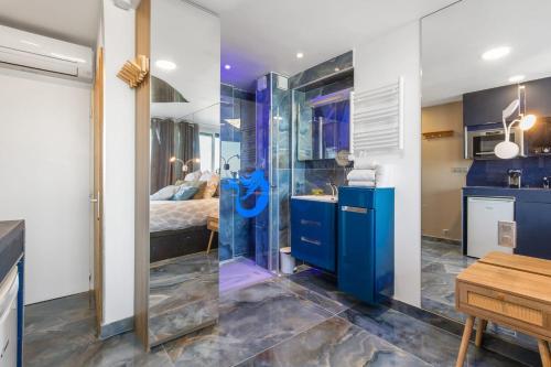 La salle de bains est pourvue d'une douche en verre et d'un lit. dans l'établissement Sea Life Heliopolis, au Cap d'Agde