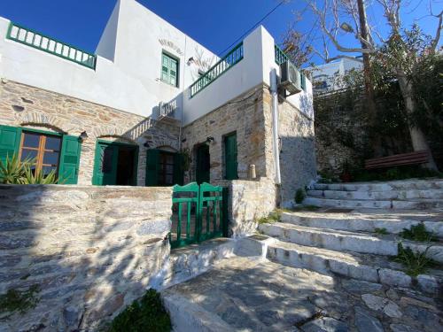 a building with stairs and a green gate at Pension Sofia Amorgos-Katapola in Katapola