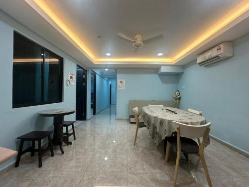 a dining room with a table and chairs and a tv at Karen Homestay Likas in Kota Kinabalu