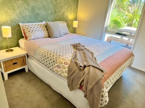 a bedroom with a bed and a window at Miranda Oasis in Torquay