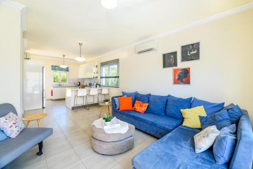 a living room with a blue couch and a kitchen at Protaras Holiday Villa - Katia 8B in Protaras