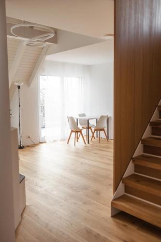 a living room with a table and chairs and a staircase at VK - H - Zürich Airport - Luxury - Homestay - Haldenstrasse - Kloten in Kloten