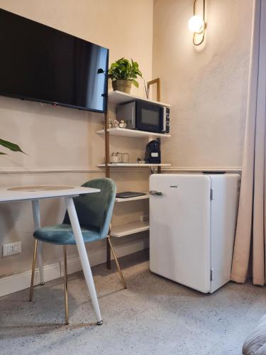 a room with a table and a refrigerator and a tv at Matteotti 54 Dimora Storica in Pavia