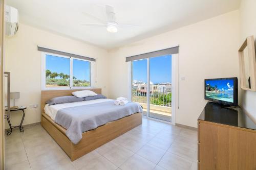 a bedroom with a bed and a flat screen tv at Protaras Holiday Villa - Katia 8B in Protaras