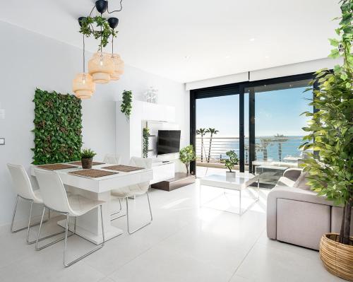 a white living room with a table and chairs at Luxury Seaview Beachfront Apartment Pools,Jacuzzi,Gym in Arenales del Sol