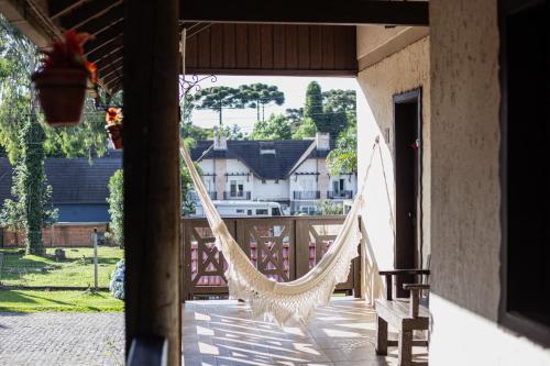 a hammock on the porch of a house at Pousada Caliandra Da Serra in Canela