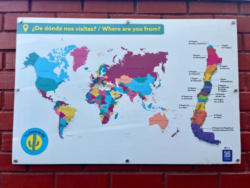 a map of the world on a brick wall at Hostel Tu Espacio RE - Habitaciones cerca del Aeropuerto in Santiago